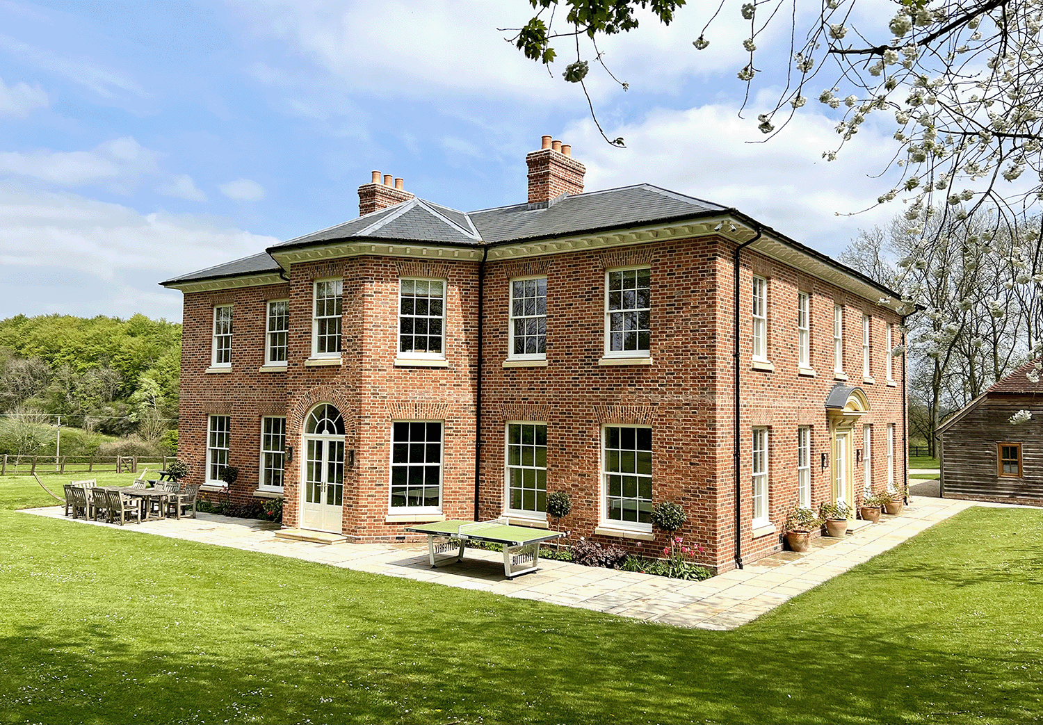 white timber casement windows and doors on the back of a red brick cambridgeshire country home